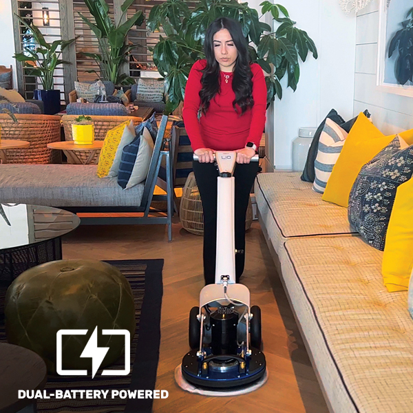 a woman in a red sweater is using a vacuum cleaner.